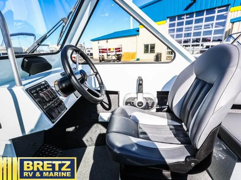 Slide: The Image of 2024 Sea Runner 210 SRET boat interior with steering wheel and captain's seat at Bretz RV & Marine. - 14
