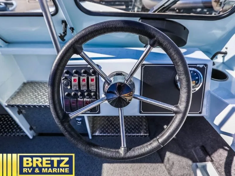 Slide: The Image of 2024 Sea Runner 210 SRET boat steering wheel and dashboard controls. - 16