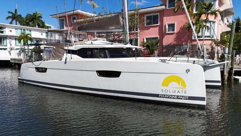 Slide: The Image of 2018 Fountaine Pajot Saona 47 catamaran docked near colorful buildings. - 0