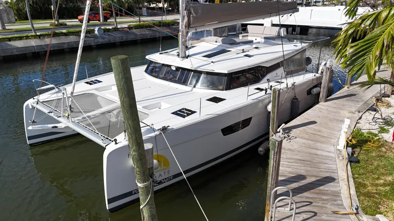 Slide: The Image of 2018 Fountaine Pajot Saona 47 catamaran docked in a serene canal setting. - 10