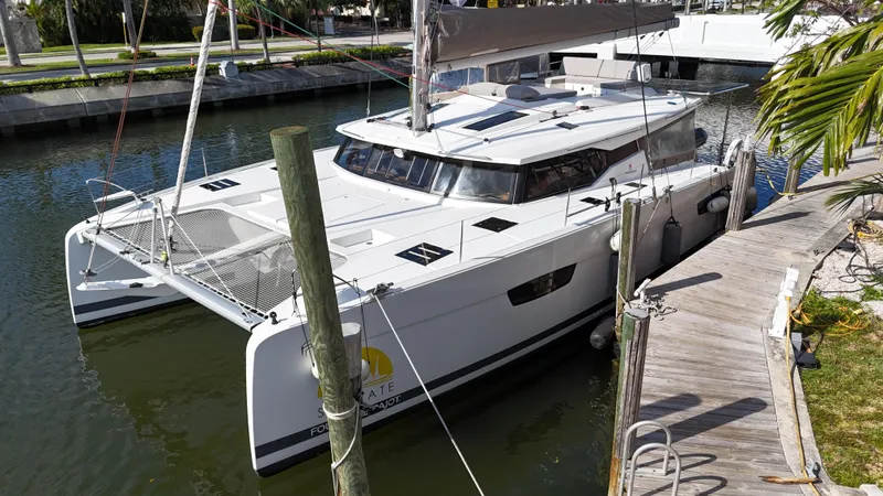 Slide: The Image of 2018 Fountaine Pajot Saona 47 catamaran docked in a serene marina setting. - 11