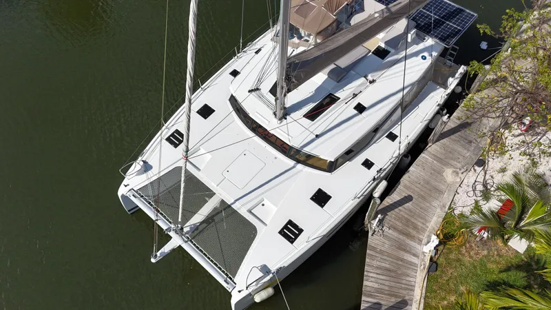 Slide: The Image of Aerial view of 2018 Fountaine Pajot Saona 47 catamaran docked by a wooden pier. - 12