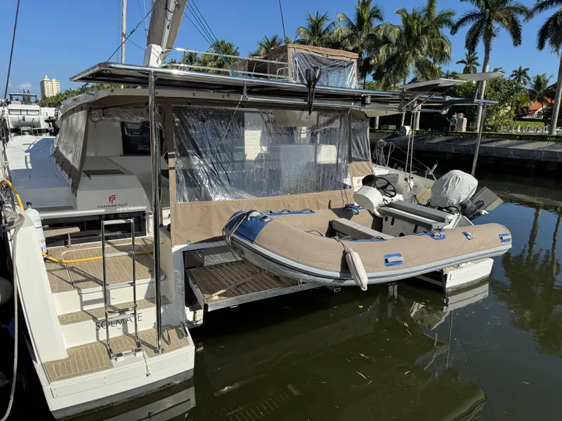 Slide: The Image of 2018 Fountaine Pajot Saona 47 catamaran docked with inflatable dinghy, surrounded by palm trees. - 16