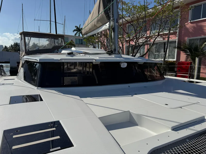 Slide: The Image of 2018 Fountaine Pajot Saona 47 catamaran docked, showcasing sleek design and spacious deck. - 18