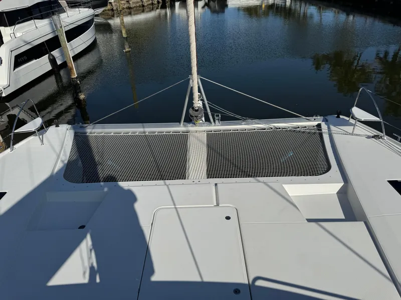 Slide: The Image of 2018 Fountaine Pajot Saona 47 catamaran docked, featuring spacious deck and netting. - 19