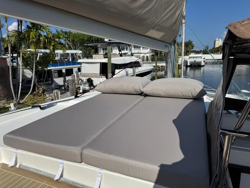 Slide: The Image of 2018 Fountaine Pajot Saona 47 catamaran with sunbathing cushions, docked near palm trees. - 28