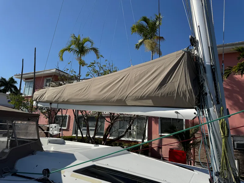 Slide: The Image of 2018 Fountaine Pajot Saona 47 sailboat with covered boom, docked near palm trees and pink building. - 32