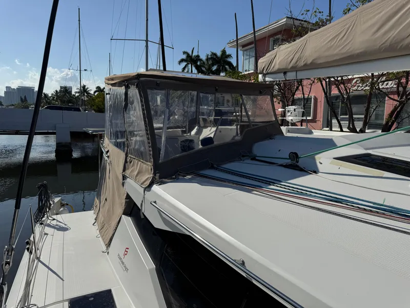 Slide: The Image of 2018 Fountaine Pajot Saona 47 catamaran docked, featuring a covered cockpit and sleek design. - 33