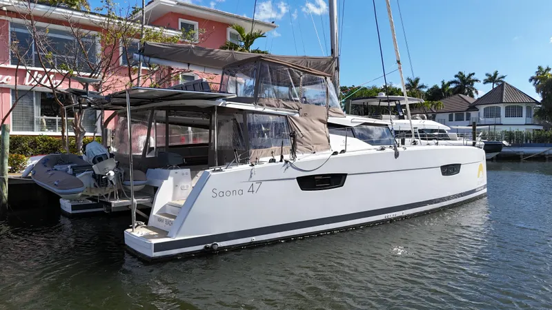Slide: The Image of 2018 Fountaine Pajot Saona 47 catamaran docked near waterfront homes. - 4