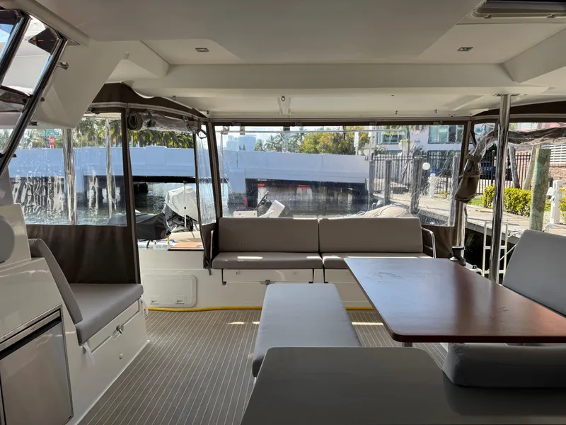 Slide: The Image of Interior of 2018 Fountaine Pajot Saona 47 catamaran with seating and table, docked at marina. - 44