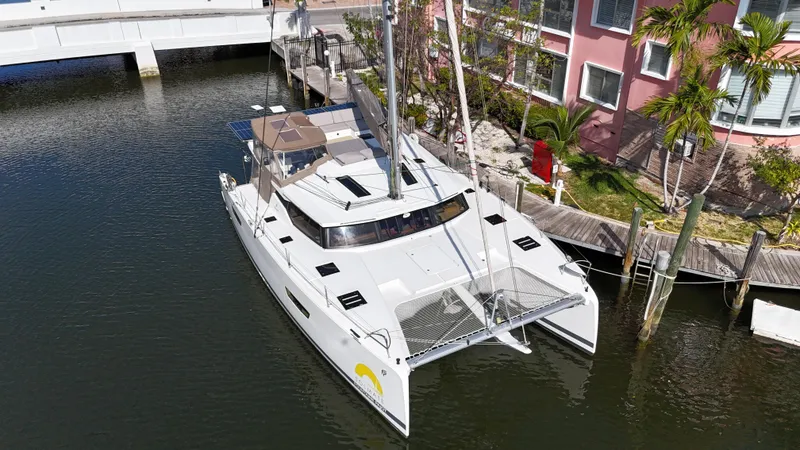 Slide: The Image of 2018 Fountaine Pajot Saona 47 catamaran docked near waterfront property. - 5