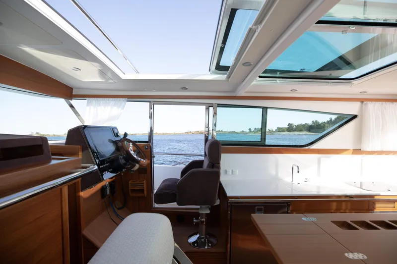 Slide: The Image of Interior of 2025 Delta Powerboats 400 SW, featuring modern helm and panoramic windows. - 10