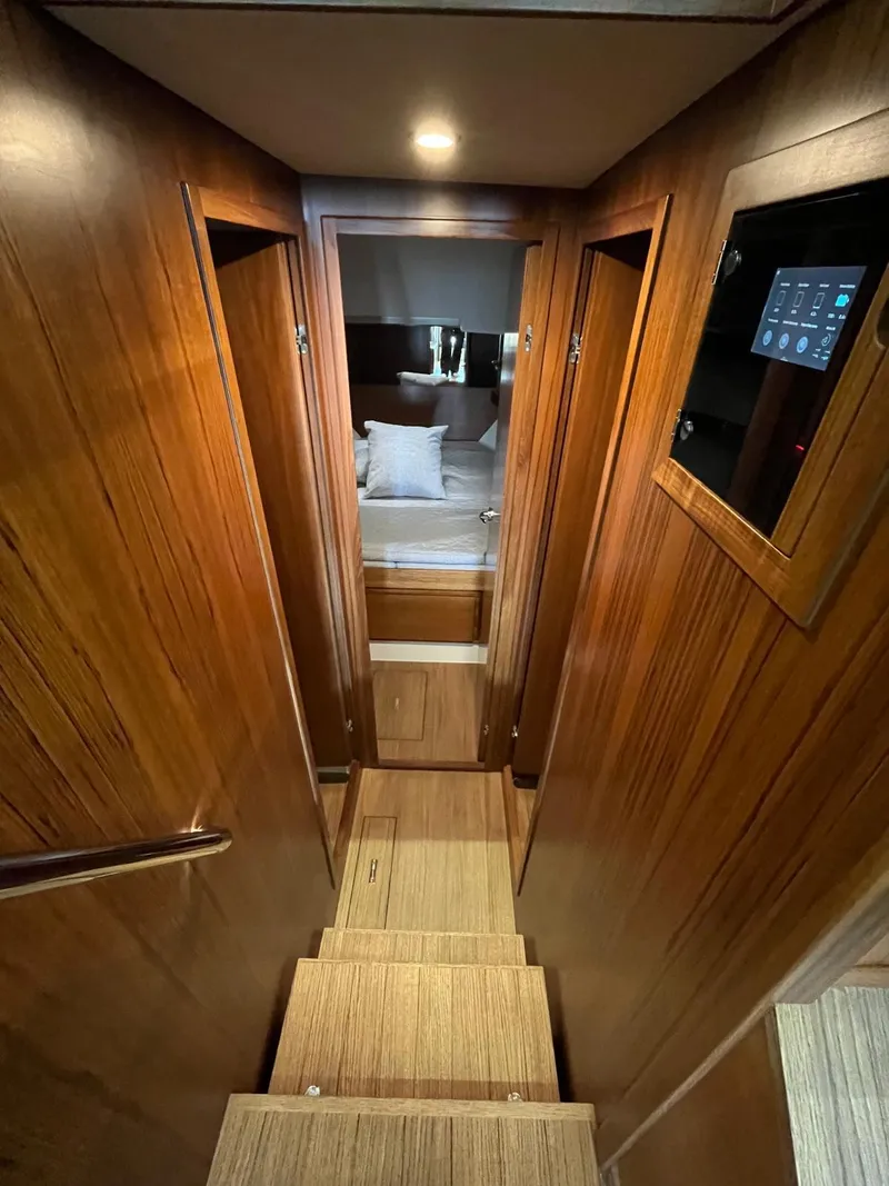 Slide: The Image of Interior of 2025 Delta Powerboats 400 SW, featuring wooden stairs and modern cabin design. - 12