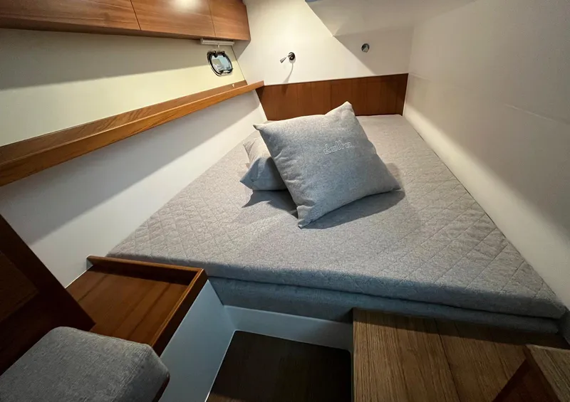 Slide: The Image of 2025 Delta Powerboats 400 SW cabin with cozy bed and wooden accents. - 15