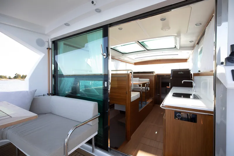 Slide: The Image of Interior view of 2025 Delta Powerboats 400 SW, featuring modern seating and kitchen area. - 6