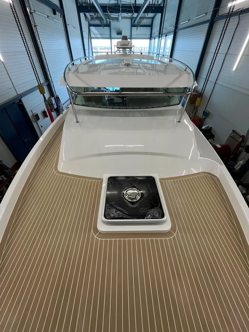 Slide: The Image of 2025 Delta Powerboats 400 SW with sleek deck design in a modern marina setting. - 8