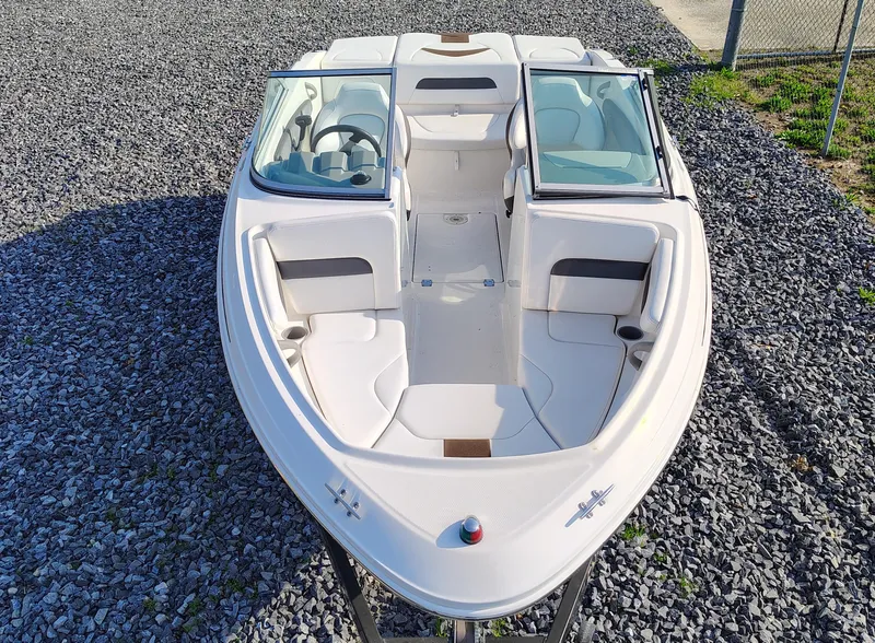 Slide: The Image of 2012 Chaparral 18 Sport H2O boat, white exterior, parked on gravel. - 2