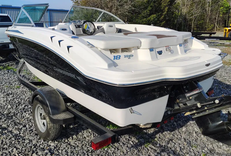 Slide: The Image of 2012 Chaparral 18 Sport H2O boat on trailer, parked on gravel, with trees in background. - 5