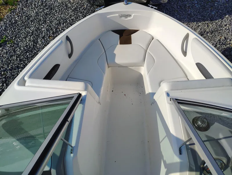 Slide: The Image of 2012 Chaparral 18 Sport H2O boat interior with white seating and open windshield. - 9