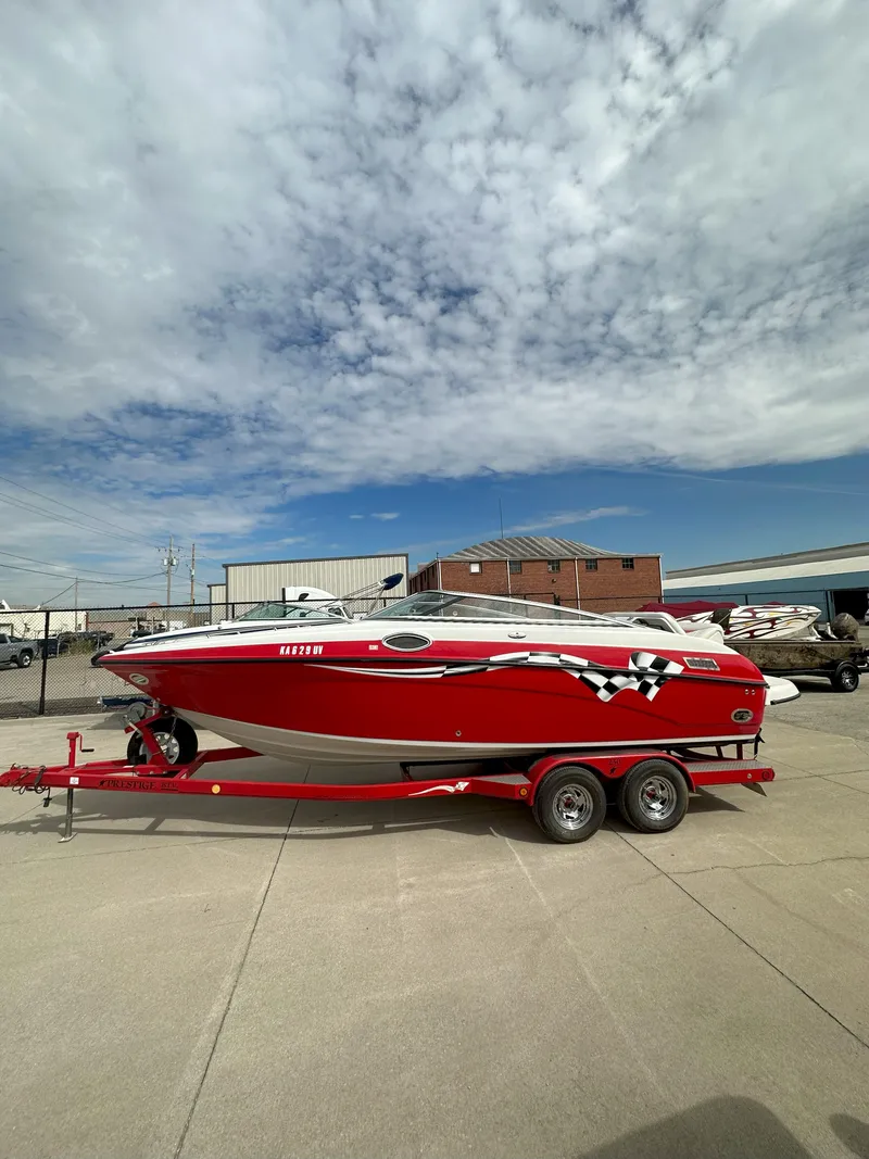 Slide: The Image of Red 2003 Crownline 230 boat on trailer under cloudy sky. - 1