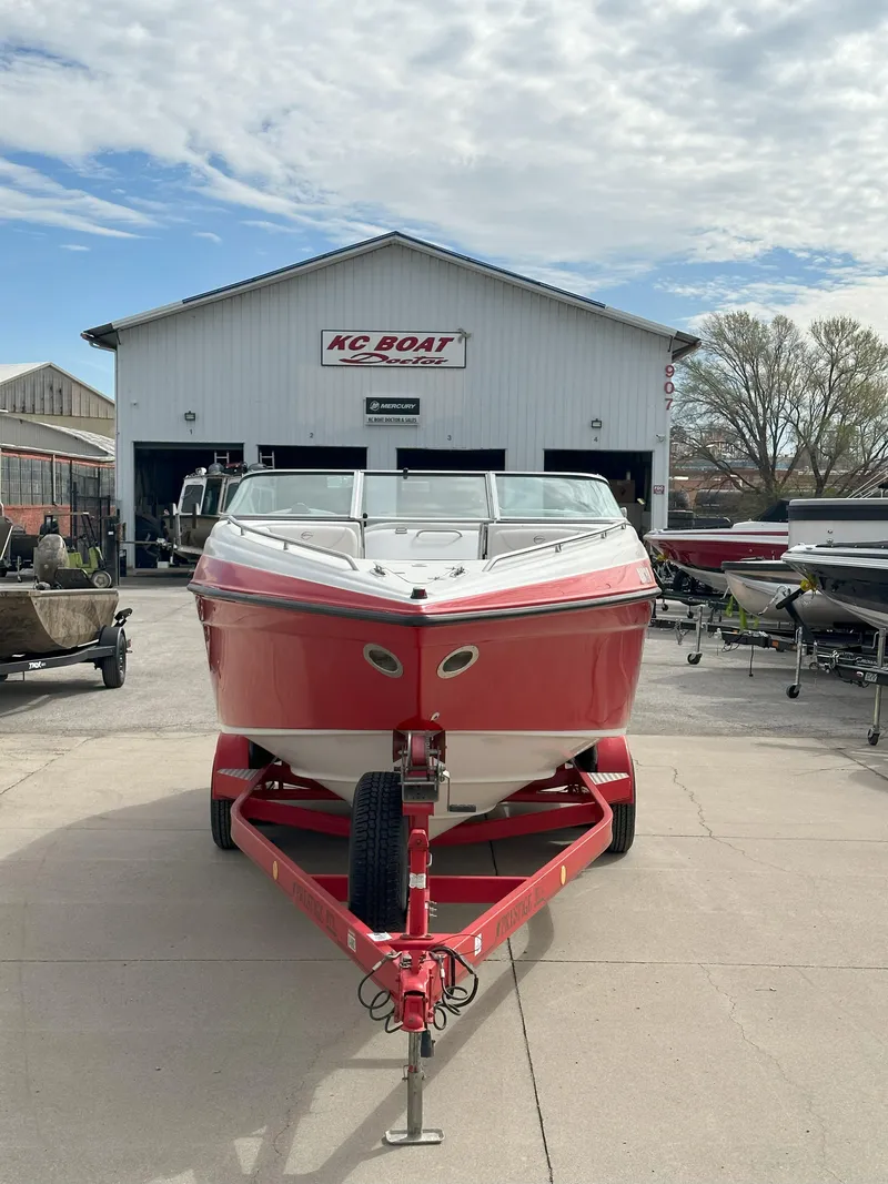 Slide: The Image of Red 2003 Crownline 230 boat on trailer, parked outside KC Boat dealership. - 2
