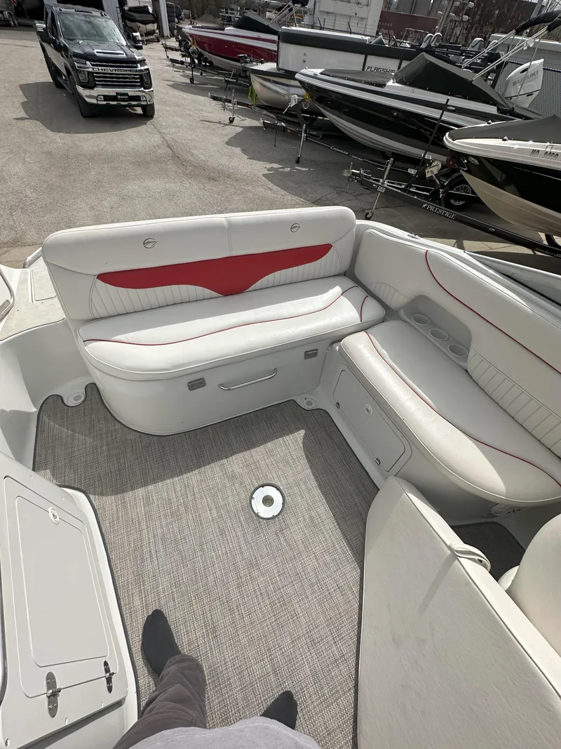 Slide: The Image of 2003 Crownline 230 boat interior with white and red seating, docked among other boats. - 7