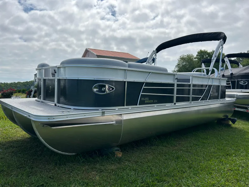 Slide: The Image of 2023 Landau Island Breeze 232 Cruise pontoon boat on grass under cloudy sky. - 5