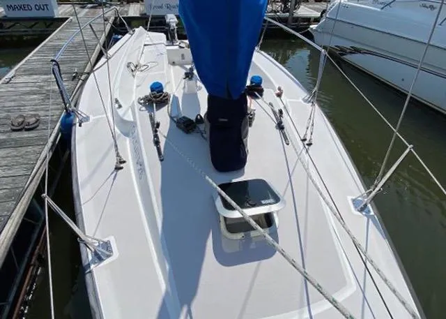 Slide: The Image of 2015 Colgate Sloop sailboat docked at marina, featuring sleek deck design and blue sail cover. - 6