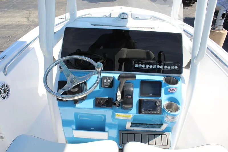 Slide: The Image of 2025 Tidewater 210 LXF boat dashboard with steering wheel and control panel. - 11