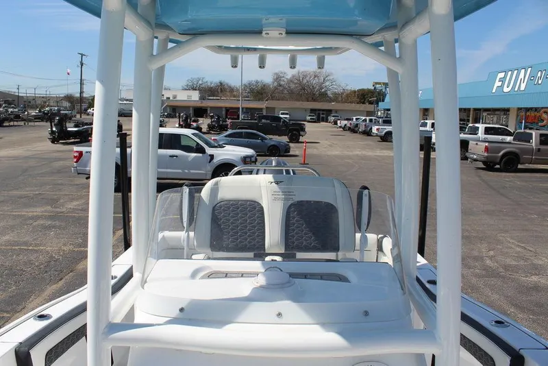 Slide: The Image of 2025 Tidewater 210 LXF boat interior with seating, parked in a dealership lot. - 19