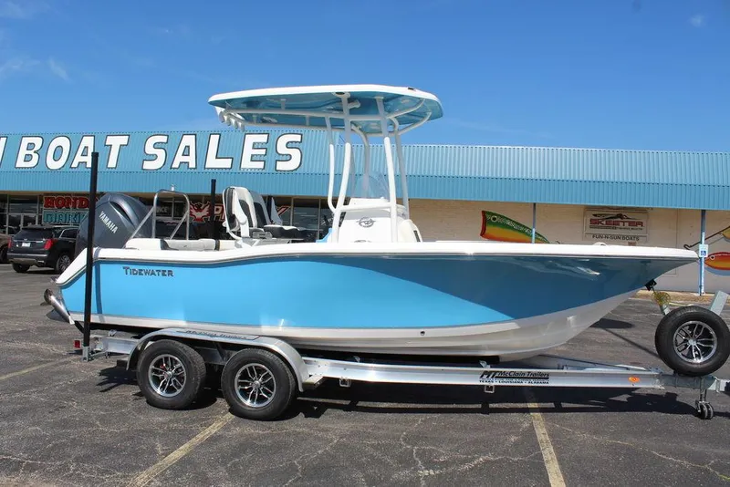 Slide: The Image of 2025 Tidewater 210 LXF boat on trailer at dealership, blue and white design. - 2