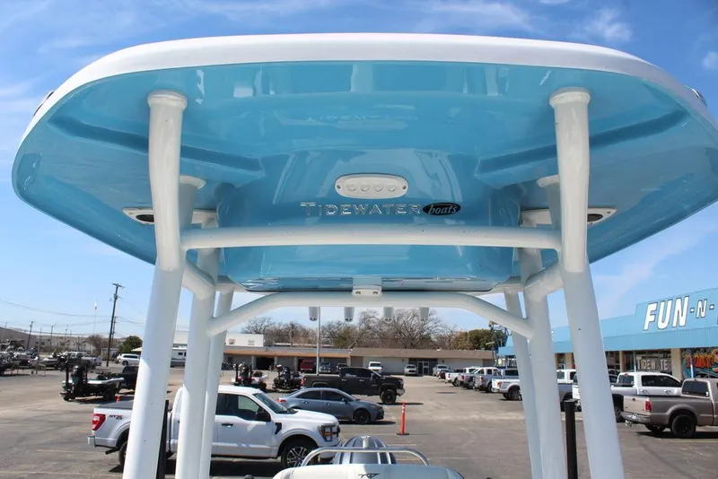 Slide: The Image of 2025 Tidewater 210 LXF boat with blue T-top, parked in a dealership lot. - 20