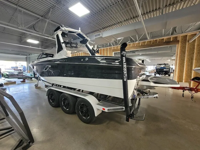Slide: The Image of 2021 Centurion Ri245 boat on a trailer in a showroom setting. - 2