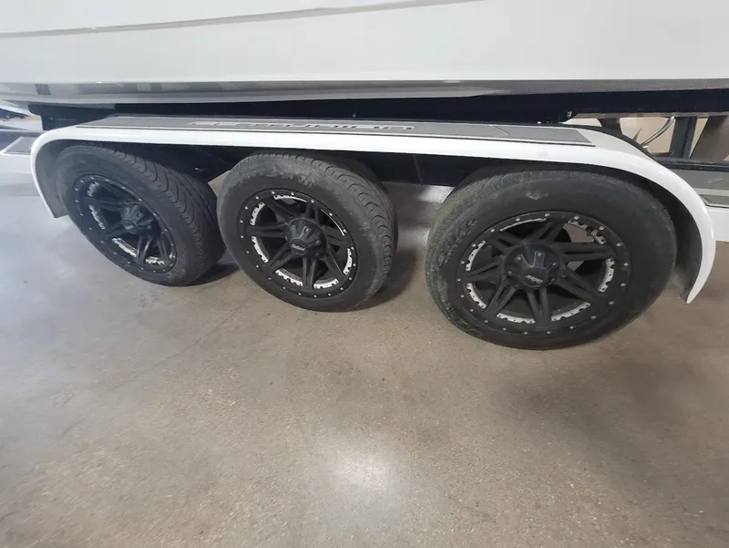 Slide: The Image of 2021 Centurion Ri245 trailer with triple black wheels on a concrete floor. - 26