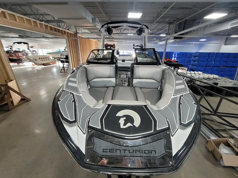 Slide: The Image of 2021 Centurion Ri245 boat in showroom, featuring sleek design and spacious seating. - 7