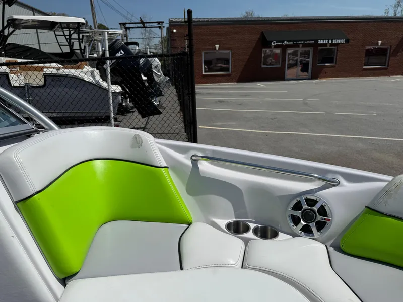 Slide: The Image of 2007 Nautique Air SV-211 boat interior with green and white seating, cup holders, and speaker. - 10