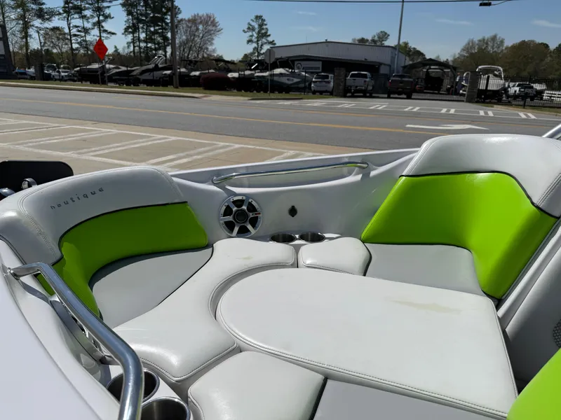 Slide: The Image of 2007 Nautique Air SV-211 boat interior with green and white seating, parked outdoors. - 11