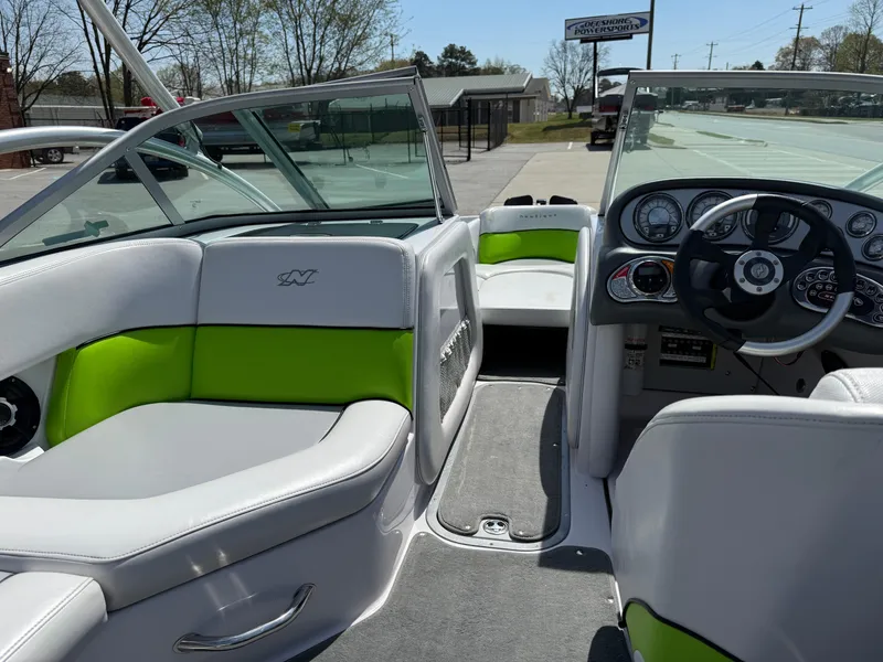 Slide: The Image of 2007 Nautique Air SV-211 boat interior with green and white seating, dashboard, and steering wheel. - 13