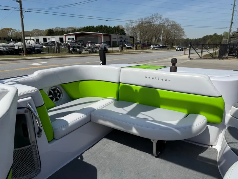 Slide: The Image of 2007 Nautique Air SV-211 boat interior with green and white seating, parked outdoors. - 14