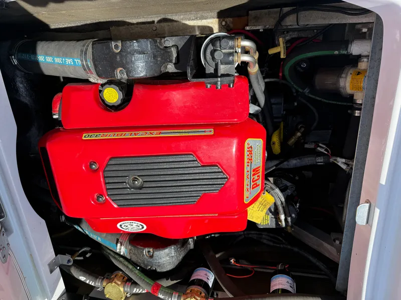 Slide: The Image of 2007 Nautique Air SV-211 engine compartment with red engine cover and visible components. - 22