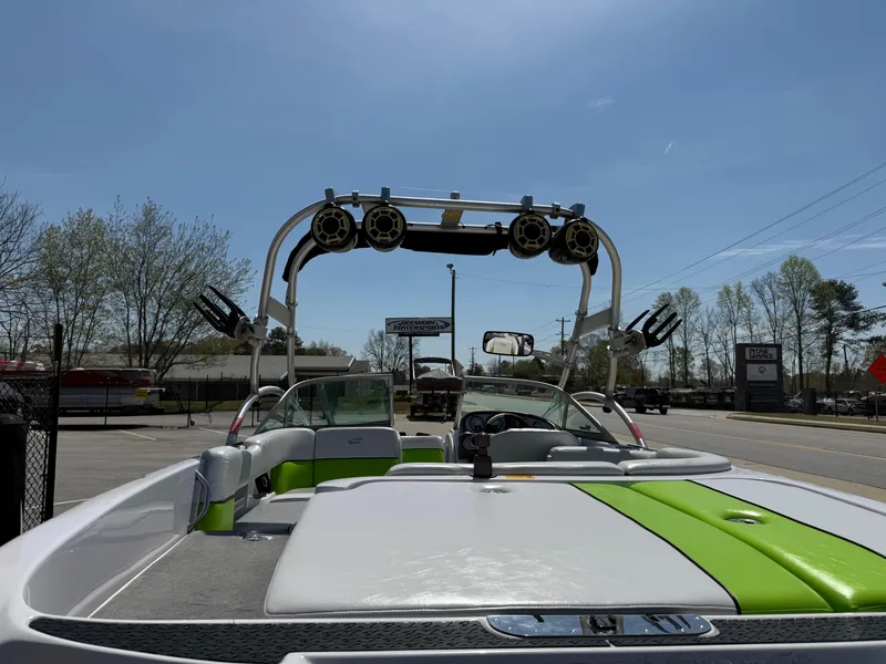 Slide: The Image of 2007 Nautique Air SV-211 boat with green accents and wakeboard tower, parked outdoors. - 29