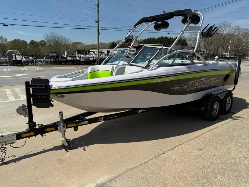 Slide: The Image of 2007 Nautique Air SV-211 boat on trailer, parked outdoors, featuring sleek design and wakeboard tower. - 3