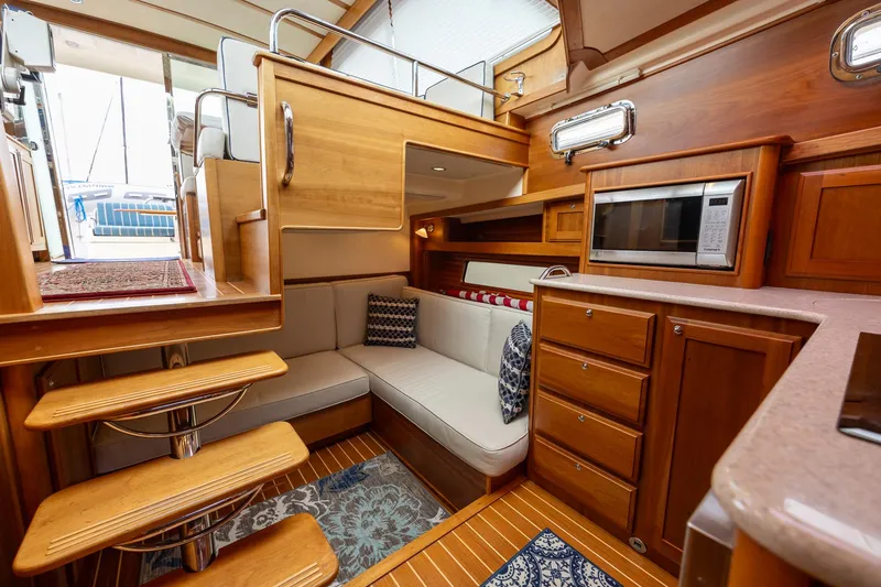 Slide: The Image of 2014 Sabre 38 Salon Express interior with wooden cabinetry, cozy seating, and modern appliances. - 14