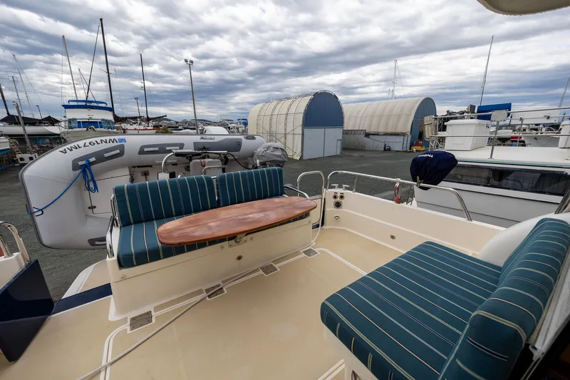Slide: The Image of 2014 Sabre 38 Salon Express yacht with outdoor seating and docked boats in the background. - 2