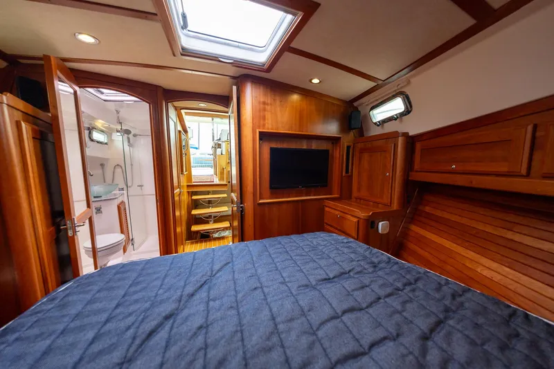 Slide: The Image of 2014 Sabre 38 Salon Express cabin with wood interior, bed, TV, and bathroom. - 22