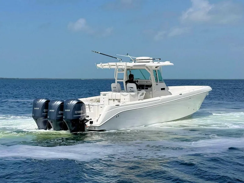 The Image of 2010 Everglades 350 CC boat with triple Yamaha engines cruising on open water. - 0