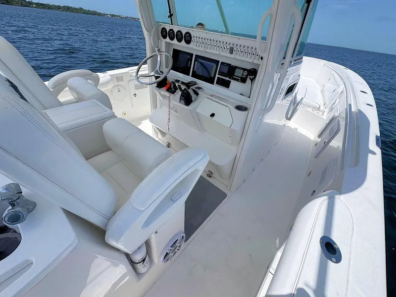 Slide: The Image of 2010 Everglades 350 CC boat interior with modern dashboard and white seating on open water. - 11
