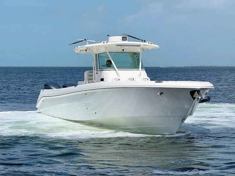 Slide: The Image of 2010 Everglades 350 CC boat cruising on open water under clear skies. - 2