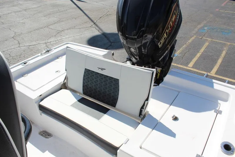 Slide: The Image of 2025 Tidewater 2300 CB boat with seating and outboard motor in a parking lot. - 16