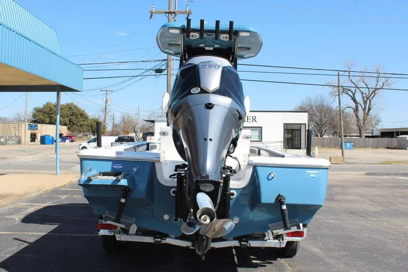 Slide: The Image of 2025 Tidewater 2300 CB boat, rear view, blue hull, parked outdoors. - 6